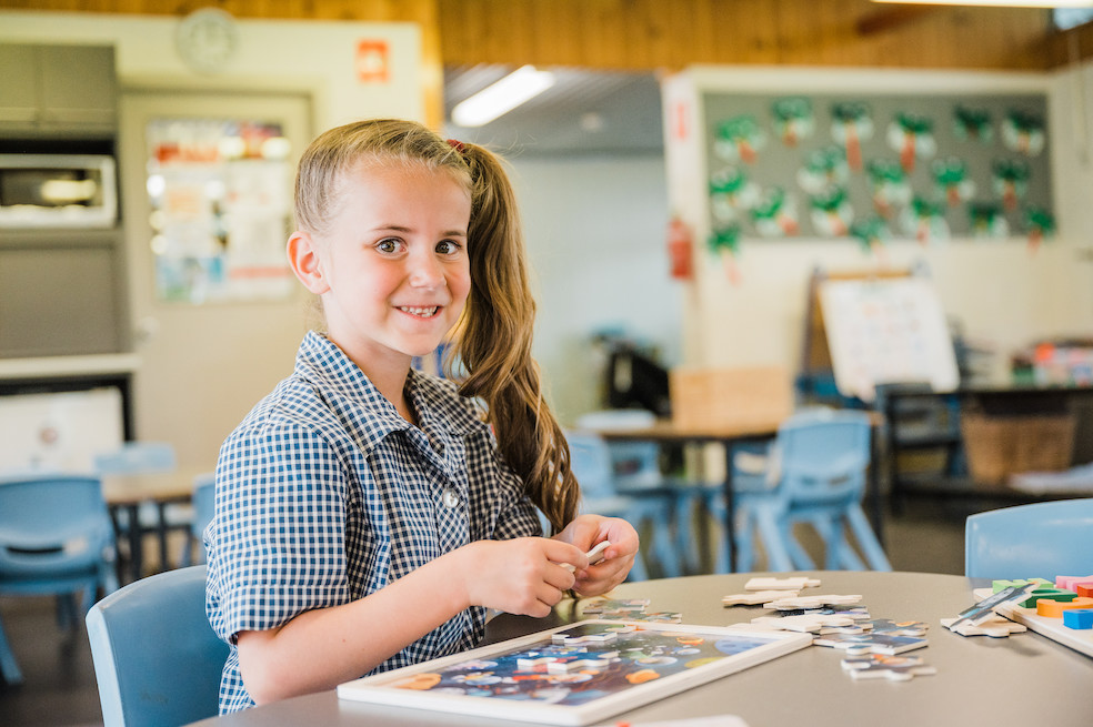 child-doing-puzzle Child doing a puzzle in classroom.