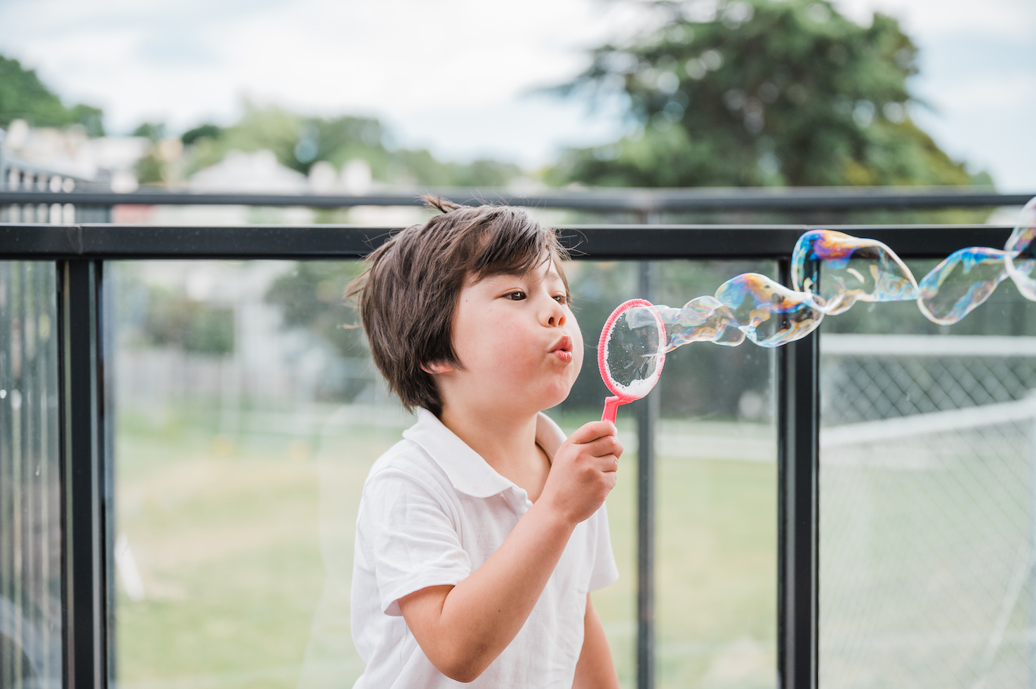 child-blowing-bubbles Child blowing bubbles outside.