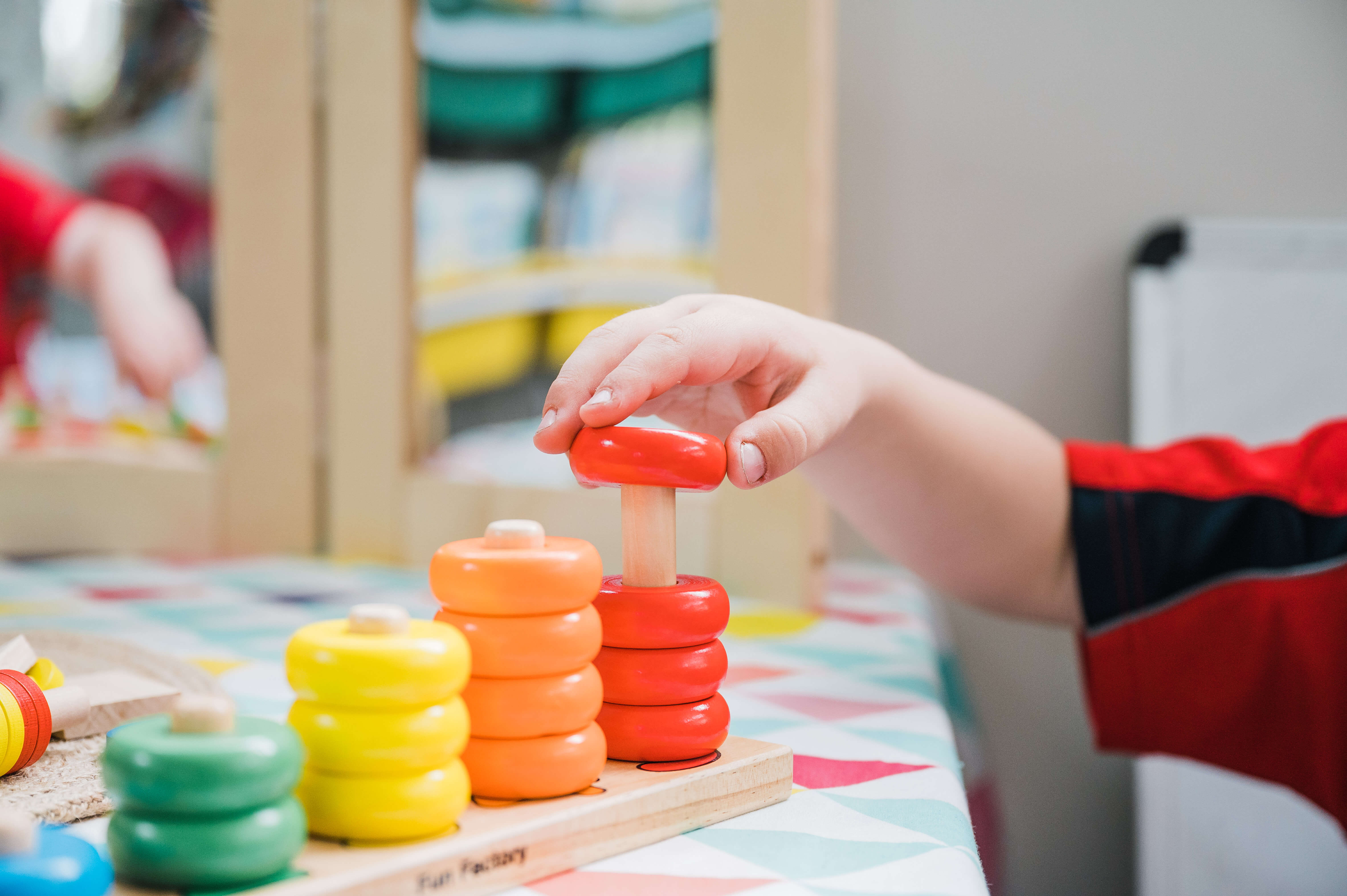 A close up of a child's hand playing with a toy.